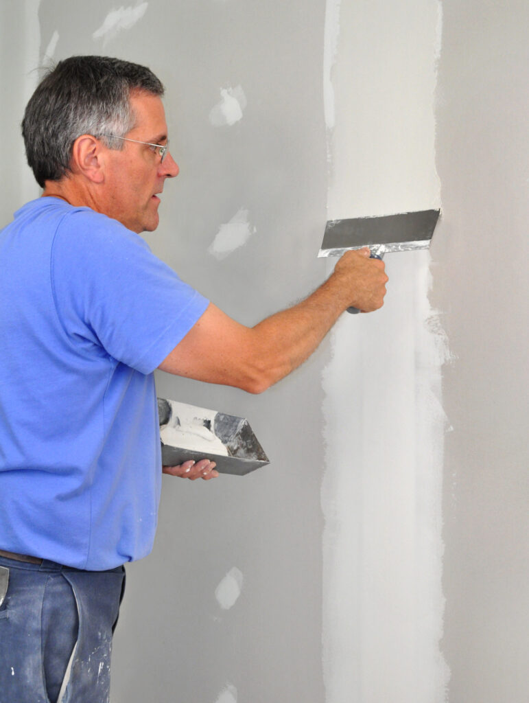 Littleton Drywall contractor applying joint compound to wall seams for a smooth finish during renovation.