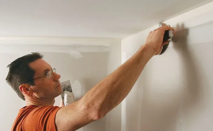 Drywall contractor applying joint compound and finishing wall seams to create a smooth paint-ready interior surface.