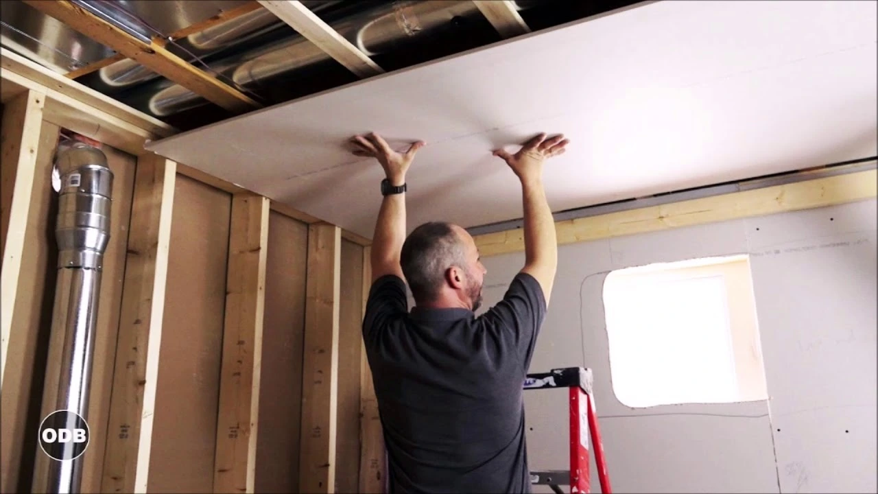 installing ceiling drywall during basement finishing and home remodeling project.